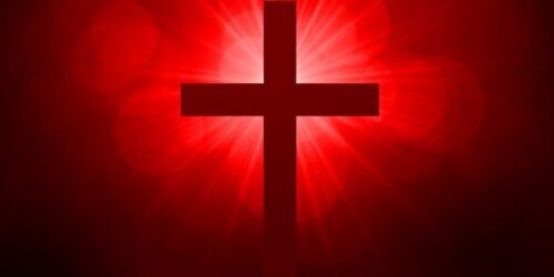 Cross surrounded by red sun rays. Easter and resurrection concept.